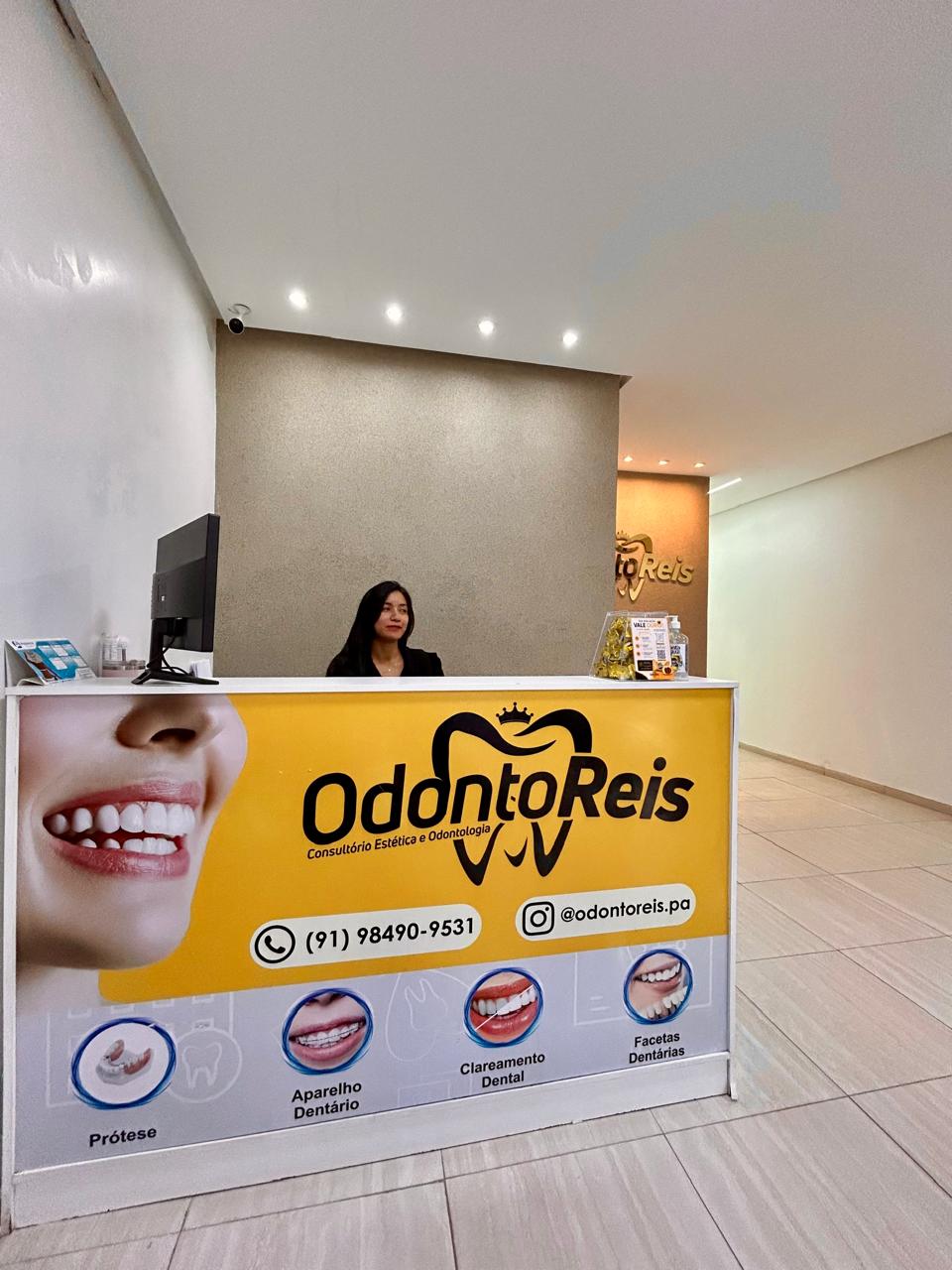 Recepção da OdontoReis com atendente e balcão personalizado